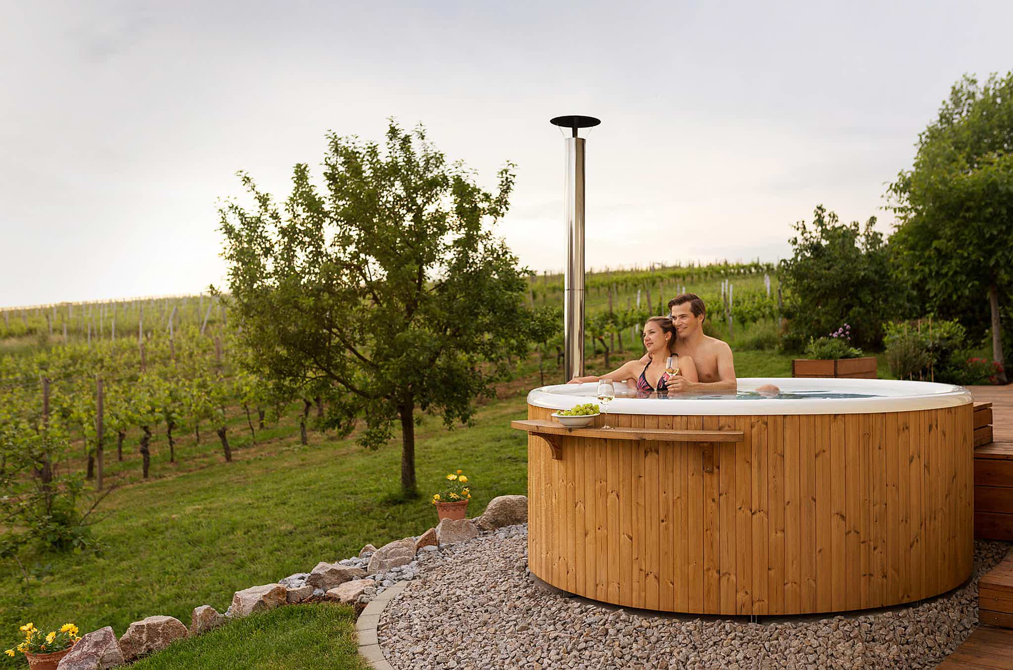 Frauke and Markus in their Skargards Regal DualBurn 220 hot tub with a vineyard view.