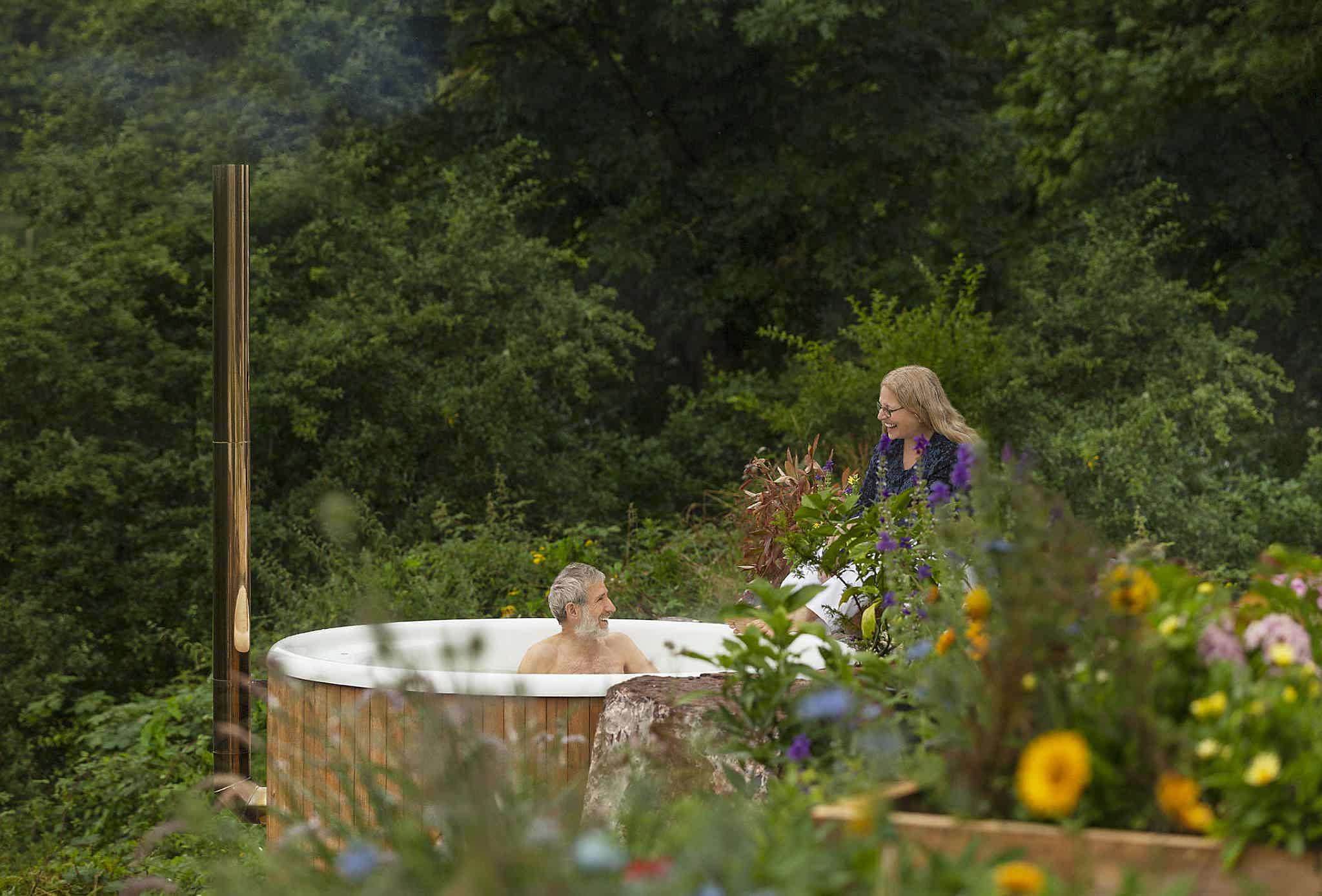 Hugh enjoys a bath in his Skargards Regal 190 hot tub, whilst his wife is standing close-by, chatting with him.