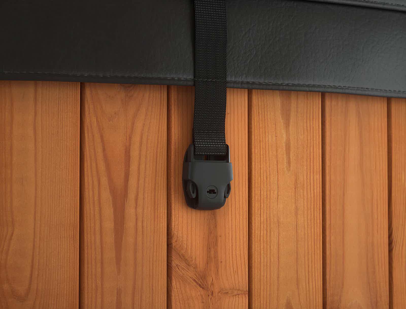 A black leather strap with holder on a wooden wall.