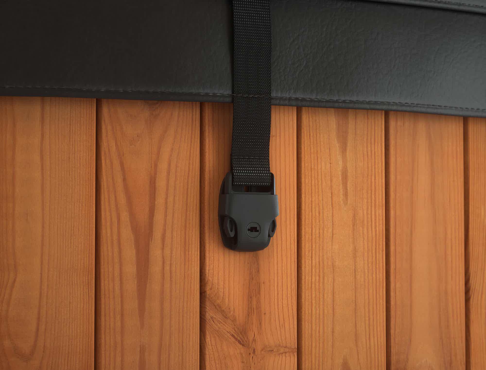 A black leather strap with holder on a wooden wall.