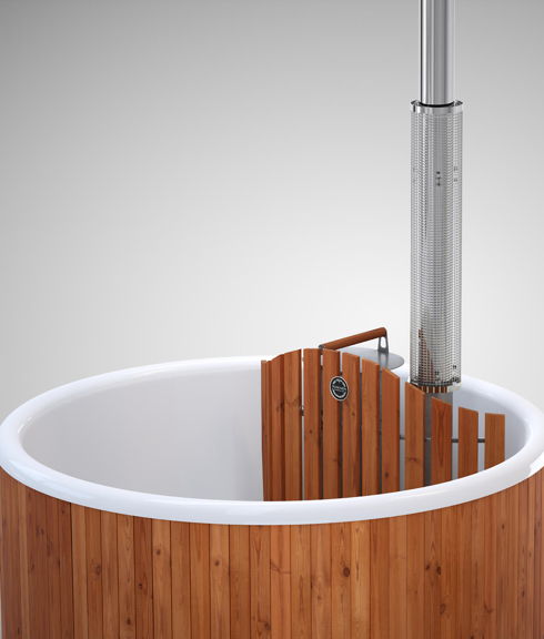 Lähikuva tytöstä istumassa puulämmitteisessä Regal-kylpytynnyrissä koroke-istuimella. 