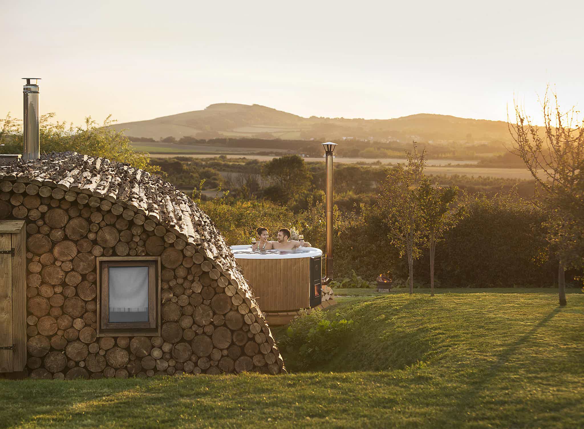 A Skargards hot tub at Tom's Eco Lodge offers a serene retreat in lush greenery, perfect for relaxation.