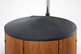 A close-up of a Skargards hot tub with a black canvas cover and silver pole.