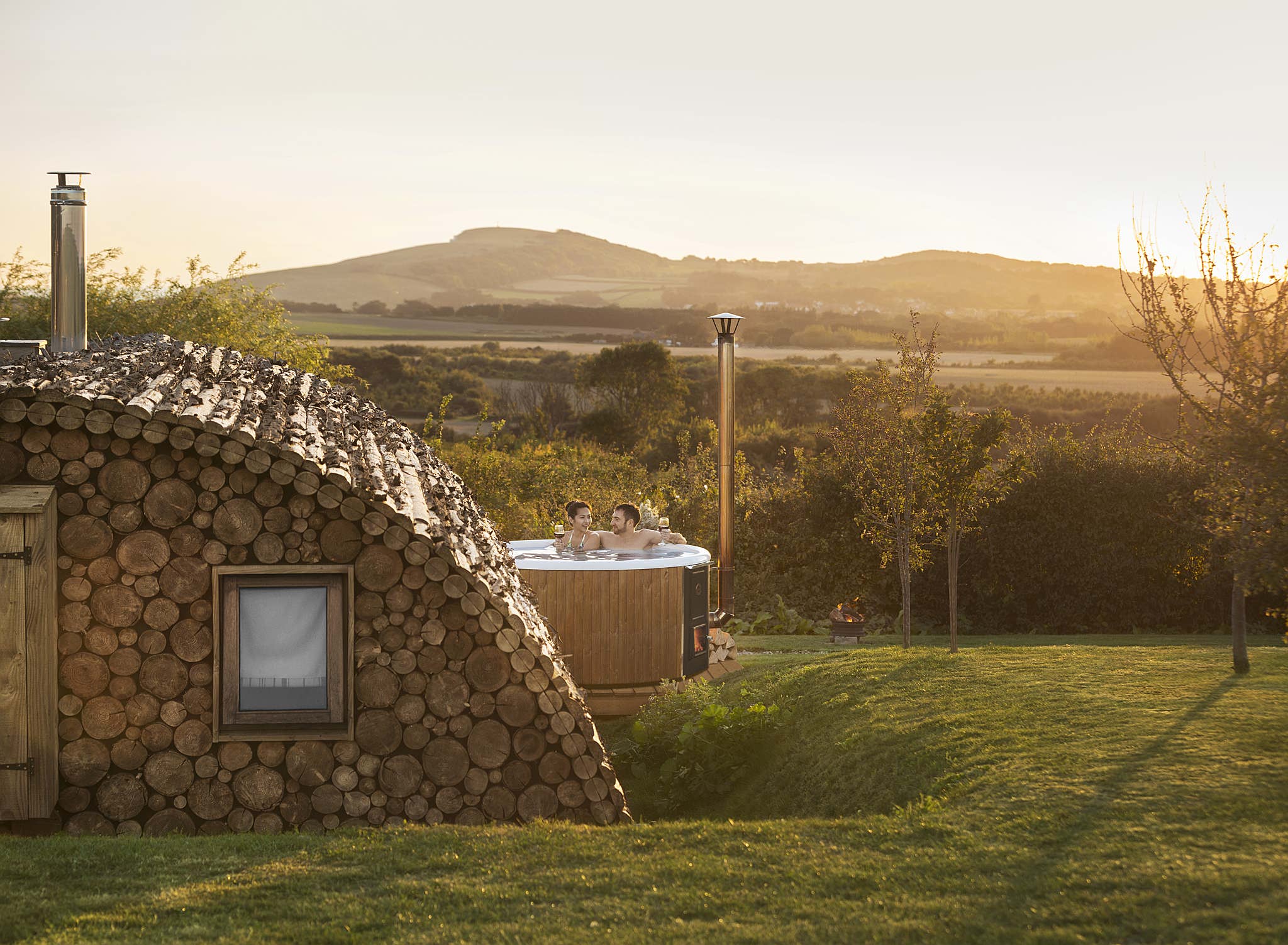 A Skargards hot tub at an eco lodge offers a serene retreat in lush greenery, perfect for relaxation.