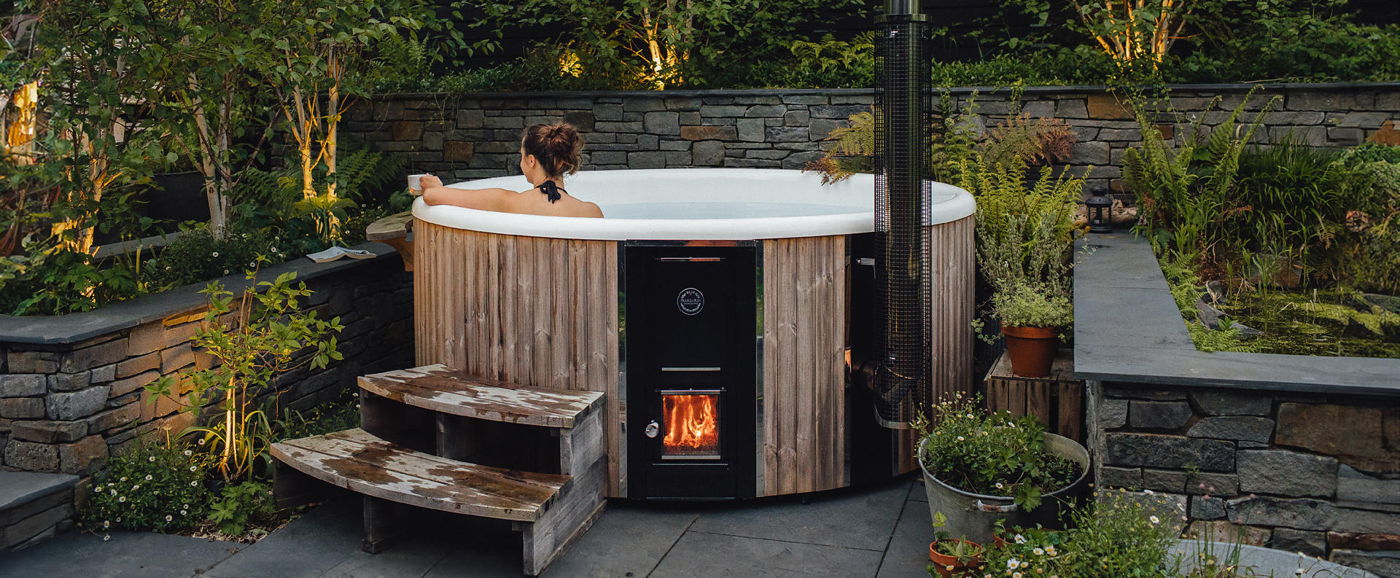 Victoria Wade sitzt entspannt in ihrer selbst gestalteten Wellnessoase mit einem Skargards Hot Tub 