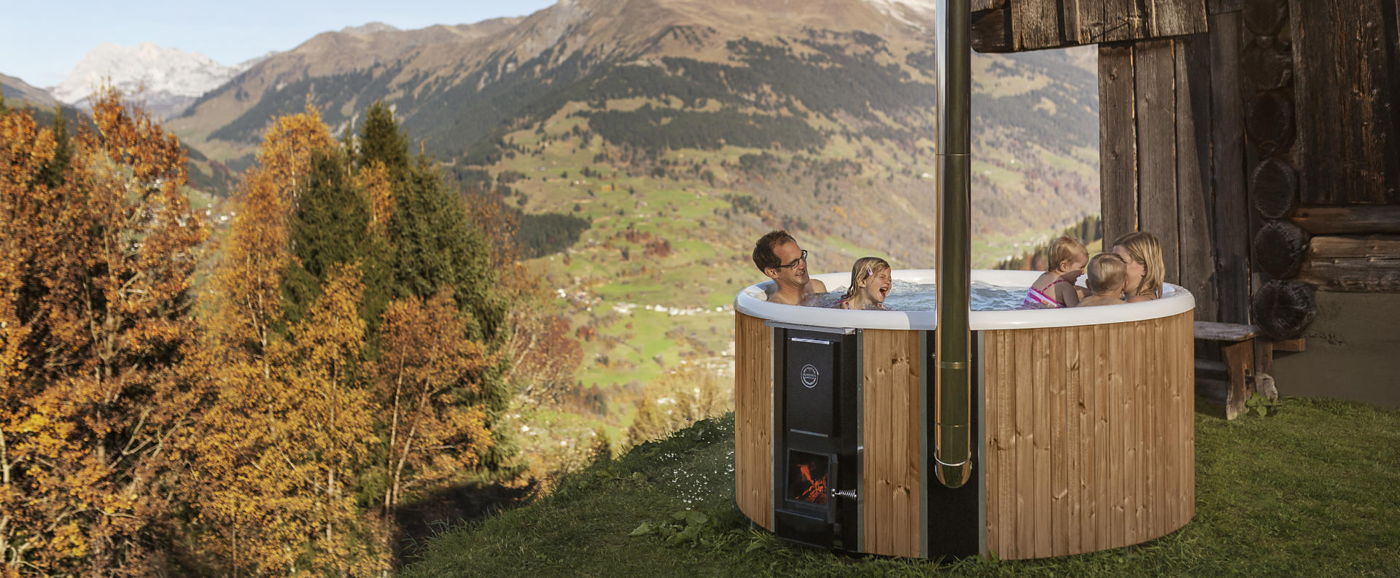 Perhe nauttii kylvystä Skargards Regal -kylpytynnyrissä Sveitsin vuorilla. 