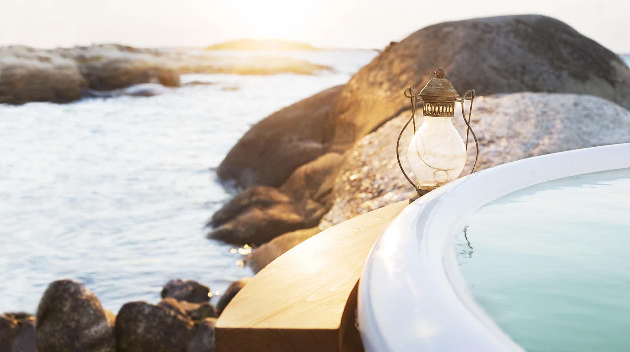 A wooden side table next to a Skargards hot tub, perfect for holding drinks or towels.