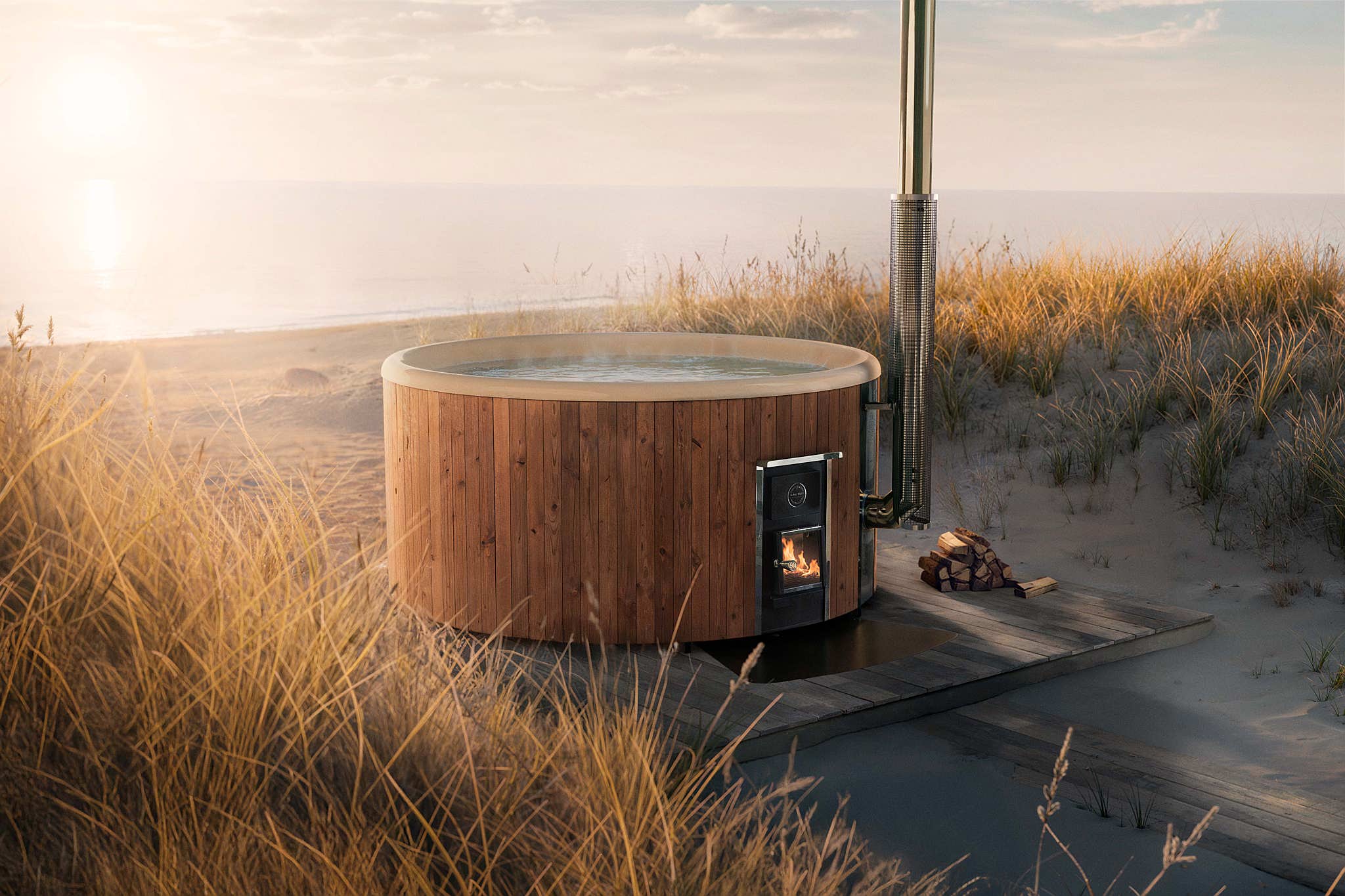A wooden hot tub on a grassy beach with sunset.