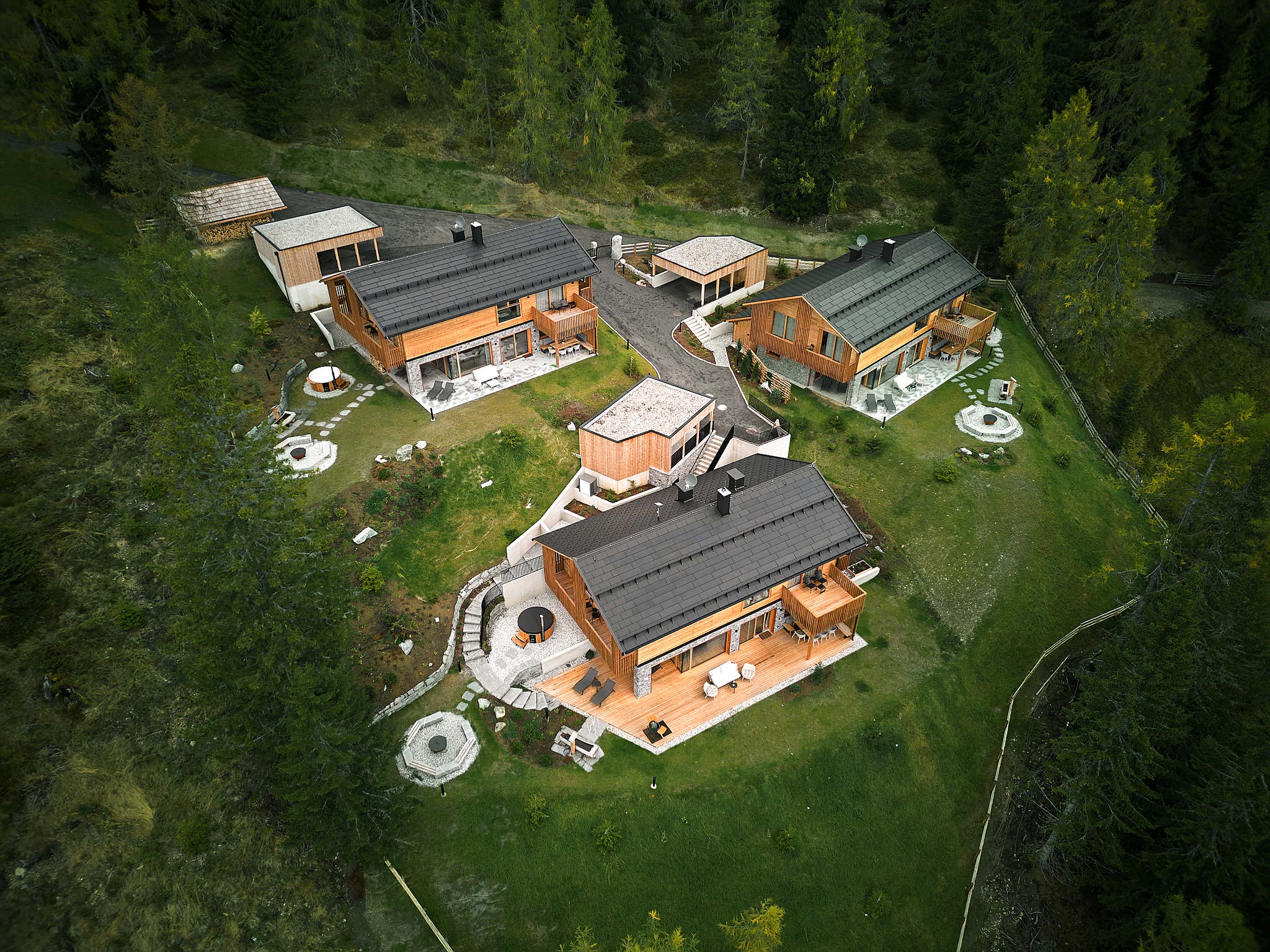 Aerial view of a large house with patio, pool, trees, and garden.