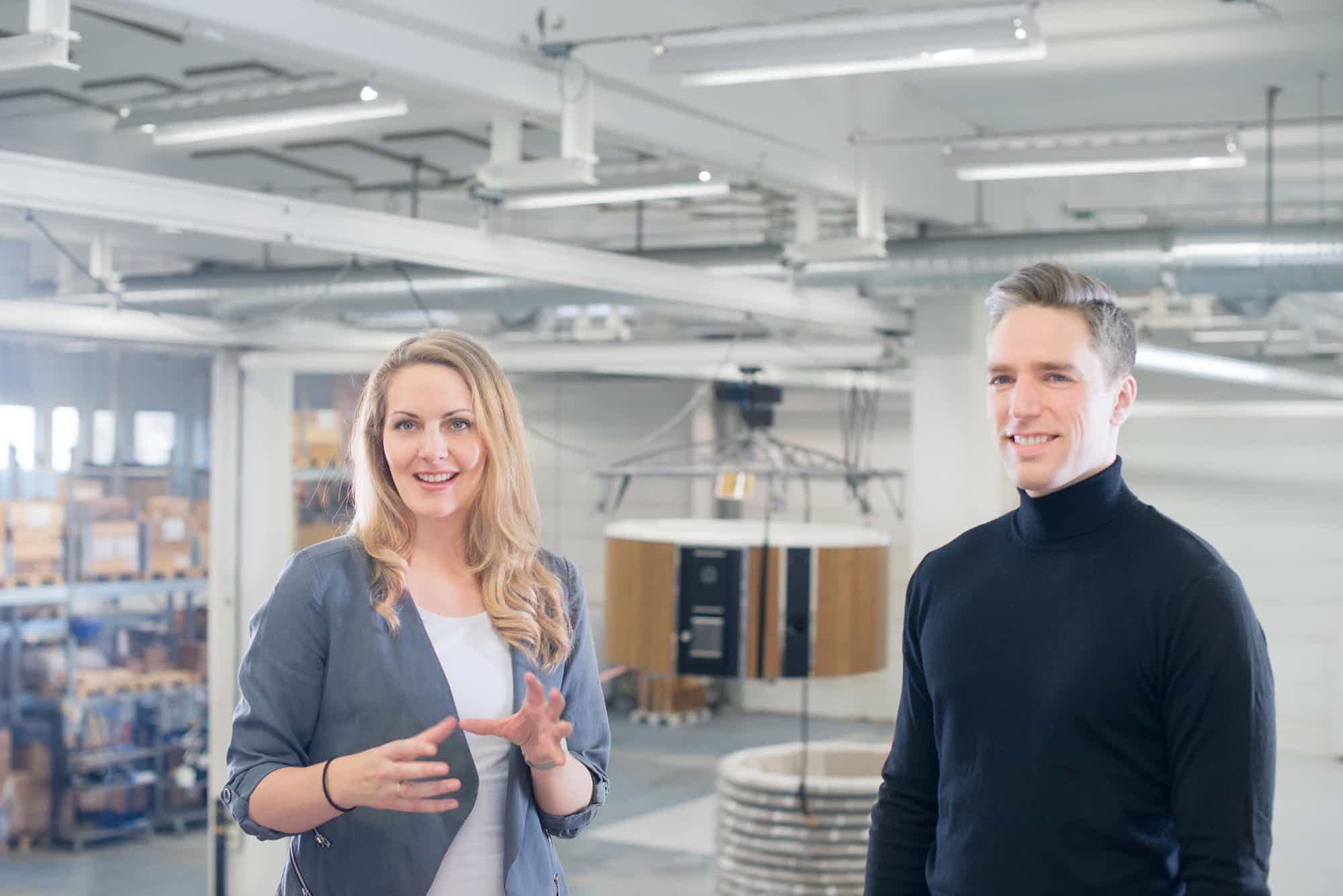 Two people in business attire converse in a warehouse with the Regal Dualburn model in background.