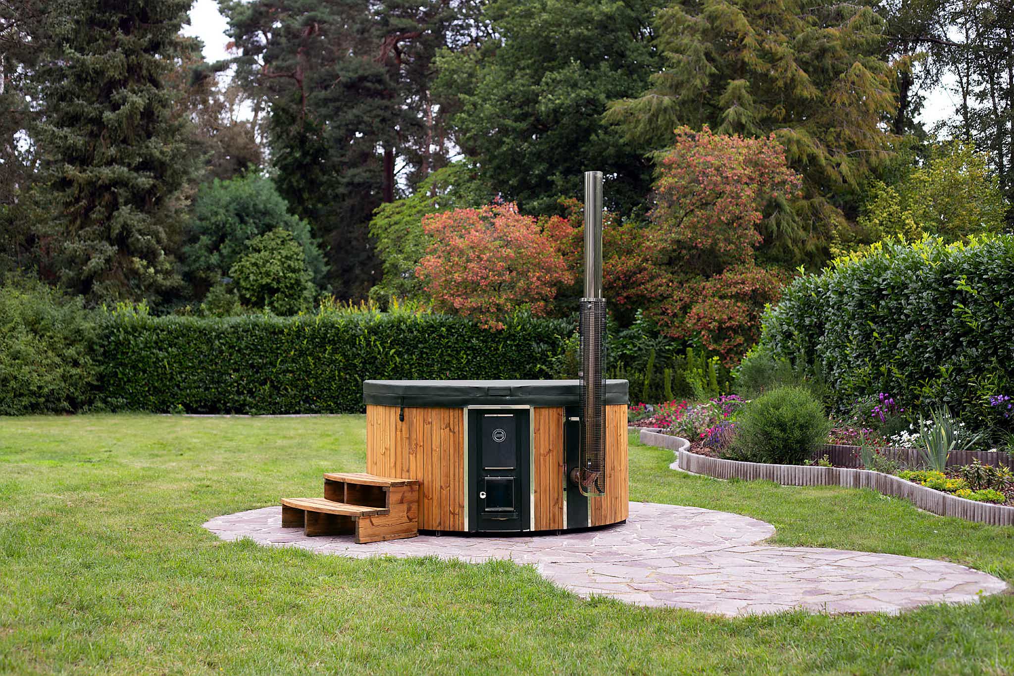 A fully refurbished Skargards Regal DualBurn 190 hot tub with a premium insulated lid in a lush garden setting.
